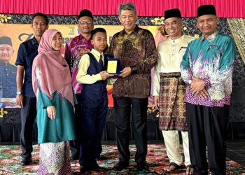 MOHAMAD Hasan menyampaikan anugerah kepada pelajar cemerlang selepas merasmikan Mesyuarat Agung Tahunan Persatuan Ibu Bapa dan Guru (PIBG) Sekolah Kebangsaan Taman Tuanku Jaafar Ke-26 di Seremban hari ini.-UTUSAN/ZAKKINA WATI AHMAD TARMIZI.