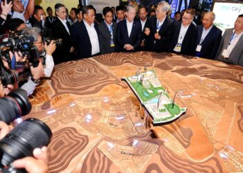 FADILLAH Yusof bersama Aminuddin mendengar penerangan mengenai pembangunan kawasan MVV 2.0 pada Majlis Peluncuran Projek Katalis MVV 2.0 di Port Dickson hari ini.-UTUSAN/MOHD. SHAHJEHAN MAAMIN.