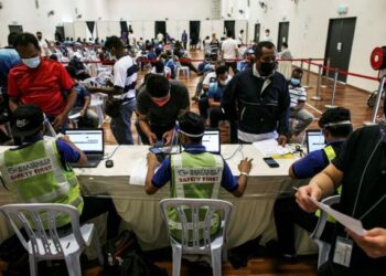 PETUGAS laut dan pekerja pelabuhan melakukan pendaftaran bagi menerima suntikan vaksin di Pusat Pemberian Vaksin (PPV) Sektor Pengangkutan (maritim) di Dewan Kompleks Sukan Pelabuhan Klang.  - UTUSAN/ZULFADHLI ZAKI