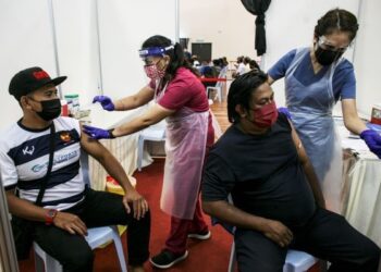 PETUGAS pelabuhan menerima suntikan vaksin di Pusat Pemberian Vaksin (PPV) Sektor Maritim di Dewan Kompleks Sukan Pelabuhan Klang. -  UTUSAN/ZULFADHLI ZAKI