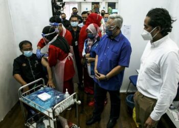 KHAIRY Jamaluddin (kanan) dan Ahli Parlimen Tanjong Karang, Tan Sri Noh Omar (tengah) melihat petugas kesihatan memberi suntikan vaksin Covid-19 kepada penduduk sekitar Tanjong Karang. - UTUSAN/ZULFADHLI ZAKI