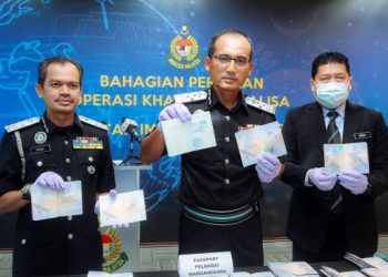 INDERA Khairul Dzaimee Daud (tengah) menunjukkan cap palsu Imigresen yang digunakan sindiket Anton di Putrajaya semalam.