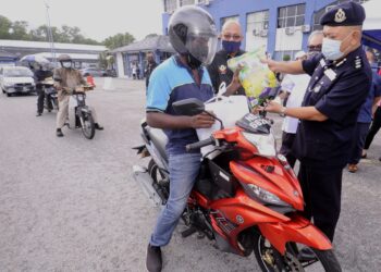  MOHD. Said Ibrahim (kanan) menyerahkan sumbangan makanan kepada individu memerlukan dalam Program Misi Prihatin Covid-19 (Siri 2) di IPD Seremban, Negeri Sembilan, hari ini. - UTUSAN/MOHD. SHAHJEHAN MAAMIN
