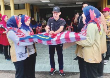 DR. Khairuddin Said (tengah) memotong riben sebagai gimik pelancaran Jalur Gemilang sepanjang 72 meter di IPG Kampus Kota Bharu, Kelantan semalam. – UTUSAN/ROSLIZA MOHAMED