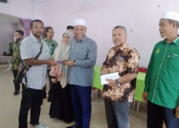 IDRIS Ahmad menyampaikan sumbangan bantuan kepada mangsa banjir di Dewan Air Kuning, Changkat Jering di Bukit Gantang, Perak, hari ini. - UTUSAN/WAT KAMAL ABAS