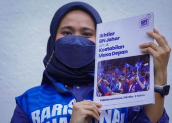 Exco Puteri UMNO, Nik Zakirah Farhanis menunjukkan manifesto Ikhtiar BN Johor di Johor Bahru. - UTUSAN/ FARIZ RUSADIO