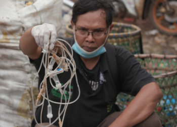 BAGONG Suyoto menunjukkan tiub saliran darah yang masih terdapat jarum pada hujungnya yang ditemukan di tempat pembuangan sampah di Kota Bekasi. – AL-JAZEERA