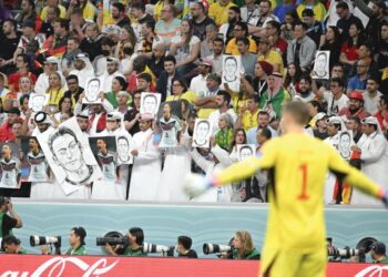 PENONTON memegang potret Mesut Ozil ketika Jerman menentang Sepanyol dalam aksi Kumpulan E, Piala Dunia 2022 di Stadium Al Bayt semalam. – AFP