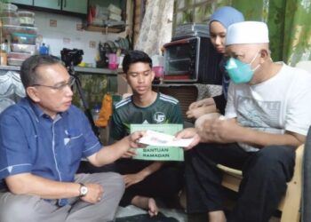 ZAINAL Kamardin (kanan) menerima sumbangan wang tunai dan barangan keperluan daripada Zaid Zain di kediamannya di Flat Sagu 34, Taman Daya, Johor Bahru.