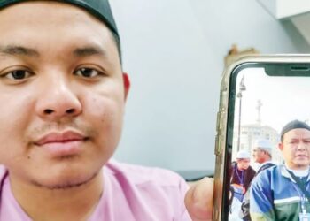 MOHD. Nabil Mustafa Kamal menunjukkan gambar ayahnya, Musthafa Kamal Abdullah yang hilang di Mekah ketika mengerjakan umrah pada 12 Disember tahun lalu. – FOTO/ADNAN IBRAHIM