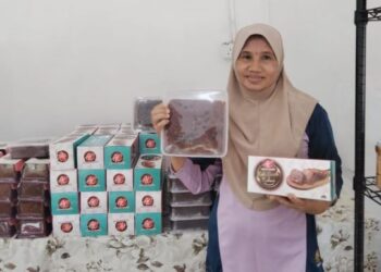NORMAH Tewiran menunjukkan kek buah kukus jenama Anugerah Cemerlang yang dihasilkannya di Kampung Parit Markom, Benut, Pontian, Johor.