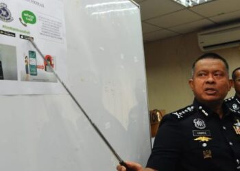 KAMARUL Zaman Mamat menunjukkan aplikasi 'Whoscall' yang boleh mengesan panggilan daripada scammer dalam sidang akhbar di IPK Johor, Johor Bahru.