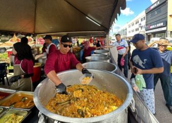 MOHD. Noor Azam Sujari melayan pelanggan yang membeli menu nasi beriani bersama lamb shank yang dijual di bazar Ramadan di Bandar Utama, Segamat, Johor.