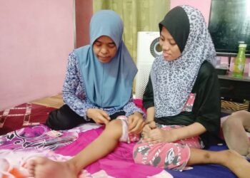 KAMISAH AB. MANAF menunjukkan keadaan kaki Aida Sofia sehingga menyebabkannya tidak boleh berjalan sejak berusia tiga tahun.