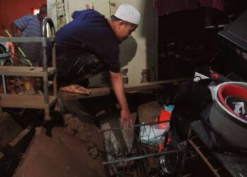 MOHAMAD Ibrahim Sujiman menunjukkan barangan dan peralatan rumah yang musnah akibat banjir kilat di Kampung Laut Batu 10, Skudai Johor Bahru.