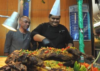 CHEF Muhammad Nurhaziq Abd. Malik memotong kambing kuzi sebagai juadah berbuka puasa di Restoran Selasih di Persada, Johor Bahru. - FOTO/RAJA JAAFAR ALI