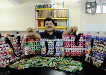 AHMAD Amirul Mohamed menunjukkan anyaman bakul yang dihasilkannya menggunakan pek plastik makanan di Persatuan Cerebray Palsy Johor, Johor Bahru. - UTUSAN/RAJA JAAFAR ALI