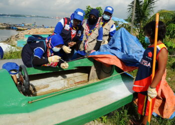 Sukarelawan Program Komunikasi untuk Perubahan Tingkahlaku (Combi) mengambil sampel jentik-jentik yang terdapat dalam sebuah bot terbiar pada Program Gotong Royong Membasmi Denggi di Kampung Orang Asli Kuala Masai, Pasir Gudang di sini, hari ini.  FOTO: RAJA JAAFAR ALI