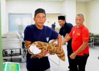 RUSLAN AHMAD mendukung jenazah cucu saudaranya yang meninggal dunia akibat didera di Hospital Sultan Ismail, Johor Bahru.