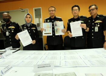 Baharuddin Tahir (tengah) menunjukan dokumen palsu dalam sidang akhbar  di   Johor Bahru semalam. - UTUSAN/BAAZLAN IBRAHIM