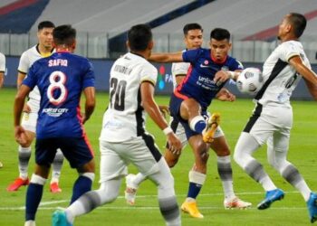 PENYERANG JDT, Safawi Rasid membuat tendangan ke arah pintu gol walaupun cuba dihalang oleh pertahanan Perak FC, Mohamd Idris di Stadium Sultan Ibrahim.  - UTUSAN/RAJA JAAFAR ALI