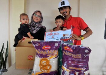 AZMIN Sakur bersama isteri dan dua anaknya menerima keperluan asas dan wang
tunai RM1,000 melalui Jelajah Ikhlas Bersama CSR di rumahnya di Felda Simpang
Waha, Kota Tinggi, baru-baru ini. - UTUSAN/RAJA JAAFAR ALI