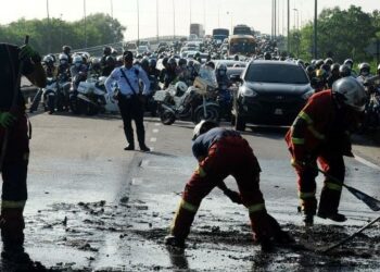 ANGGOTA bomba dan penyelamat membersihkan permukaan jalan yang berminyak dalam kemalangan jalan raya melibatkan empat buah kenderaan termasuk sebuah kereta BMW yang rentung dan menyebabkan pemandunya maut di Jalan Persisiran Pantai, Bakar Batu-Permas Jaya, Johor Bahru. - UTUSAN/RAJA JAAFAR ALI