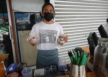 MOHD. Faiz Zul Fahmi Juraimi menunjukkan air kopi yang dijual di Lofi Coffee yang dibuka di deretan kedai batu Felda Air Tawar 5, Kota Tinggi di Johor. -UTUSAN/MASTURAH SURADI