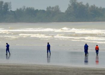 ANGGOTA Jabatan Pertahanan Awam membuat tinjauan sekiranya terdapat mayat pendatang asing yang terdampar di pantai dalam kejadian bot karam di Tanjung Balau, Kota Tinggi. – UTUSAN/RAJA JAAFAR ALI