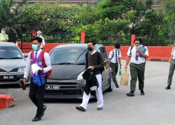 PELAJAR  tingkatan lima mematuhi SOP dengan mengenakan pelitup muka pada hari pertama sesi persekolahan dibuka khusus untuk pelajar yang akan mengambil peperiksaan di SMK Aminuddin Baki, Johor Bahru, Johor. - FOTO/RAJA JAAFAR ALI