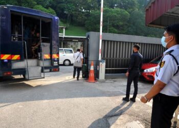 PUTERA Muhammad Syafiq Abdul Halim (kanan) mengawal pintu masuk yang membawa tahanan reman di Kompleks Mahkamah Johor Bahru di Johor. – UTUSAN/RAJA JAAFAR ALI