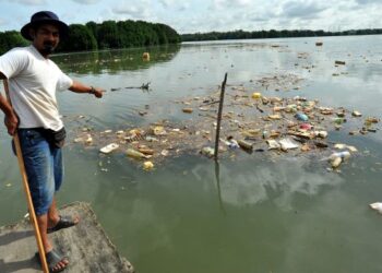 FAIZAL Daud menunjukkan sampah yang mengotori sepanjang Sungai Tebrau di Bakar Batu, Johor Bahru. - UTUSAN/RAJA JAAFAR ALI