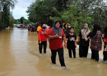 PENDUDUK kampung melihat keadaan banjir di Kampung Pogoh Tengah, Segamat baru-baru ini. - UTUSAN/RAJA JAAFAR ALI