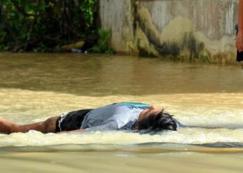 SEORANG kanak-kanak bermain air banjir di Kampung Pogoh Tengah yang masih belum surut di Segamat. - UTUSAN/RAJA JAAFAR ALI