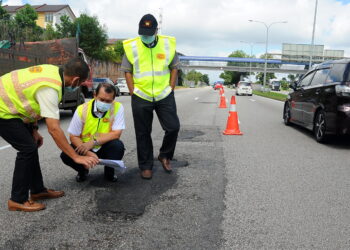 JALAN raya yang rosak perlu segera diperbaiki demi keselamatan pengguna. -GAMBAR HIASAN
