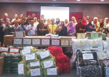 MOHD. Zawawi Zakaria (depan, lapan dari kiri) bersama kakitangan JKR Selangor yang menyumbang untuk Misi Penghantaran Bantuan Banjir Johor di JKR Selangor, Seksyen 17, Shah Alam, semalam.