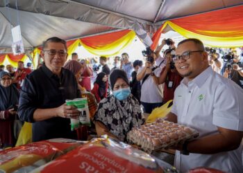 SALAHUDDIN Ayub (dua kiri) bersama Menteri Besar Selangor, Datuk Seri Amirudin Shari (kanan) beramah mesra bersama pengunjung yang membeli barangan di Tapak Jualan Mega Ehsan Rahmah (JER) selepas majlis pelancaran di Dewan Serbaguna Majlis Perbandaran Ampang Jaya (MPAJ) di sini, hari ini.-UTUSAN/FARIZ RUSADIO
