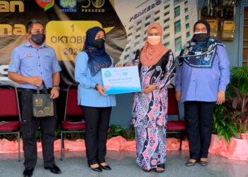 ROZIEANA AHMAD (dua dari kiri) menyampaikan cek kepada penerima insurans di bawah Akta Keselamatan Sosial Pekerja 1969 di Kangar, Perlis, semalam. – UTUSAN/NAZLINA NADZARI