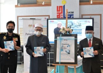 ZULKIFLI Mohamad Al-Bakri menunjukkan buku OACP Jakim selepas majlis pelancaran di Kompleks Islam Putrajaya. – GAMBAR IHSAN JAKIM