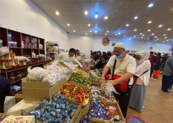 Jemaah haji memilih coklat dan makanan berasaskan kurma di ladang kurma semasa sesi ziarah luar di Madinah, semalam.