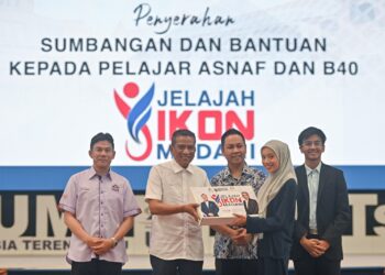MOHAMMAD Agus Yusoff (dua, kiri) menyampaikan sumbangan dan bantuan kepada pelajar asnaf pada Jelajah Ikon Madani di UMT, Kuala Nerus, Terengganu, hari ini. - UTUSAN/PUQTRA HAIRRY ROSLI