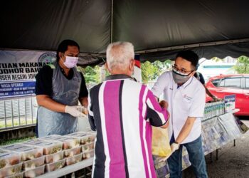 MD Derick Basir menyampaikan sumbangan kepada seorang penerima Program Bantuan Makanan Johor Port, baru-baru ini.