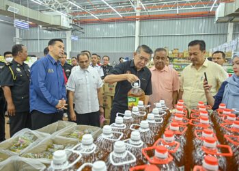 SALAHUDDIN Ayub (empat, kanan) meninjau harga minyak masak selepas merasmikan Program Jualan Rahmah di sebuah pasar raya di Jabi, Besut, hari ini. - UTUSAN/PUQTRA HAIRRY ROSLI