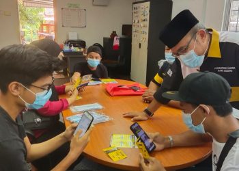 ZULKIFLI Muhamed bersama pelajar daripada golongan asnaf, fakir, anak yatim dan kurang berkemampuan yang menerima kad sim beserta akses internet percuma untuk tujuan PdP dalam talian di rumah.- UTUSAN/NOR SHAFAWATI YUP