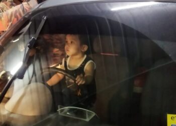 ANGGOTA bomba mengeluarkan kanak-kanak yang terperangkap dalam kereta yang terkunci di kawasan parkir sebuah pasar raya besar di Seri Manjung, Lumut semalam. - UTUSAN