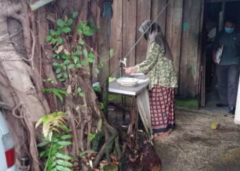 SYARIFAH AINUN  berada di hadapan rumah usangnya yang hampir ranap di Kampung Tok Ku, Sering, Kota Bharu.- UTUSAN/ROHANA MOHD NAWI