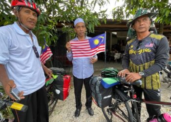 MOHD. Zaki Md. Nor (kanan) bersama Saad Nordi semasa diraikan oleh Wan Hasaan Wan Ibrahim (tengah) sebelum meneruskan kayuhan di Pasir Puteh, Kelantan hari ini.-UTUSAN/ TOREK SULONG