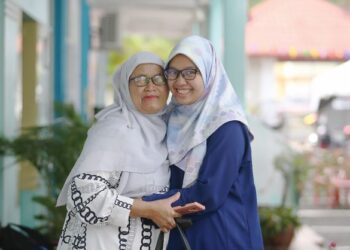 NUR Irdina Fatini Rosli yang menghidap penyakit autisme memeluk ibunya, Khairiah Abdul Kadir ketika mendaftar kemasukan di Inapan Siswa DPP Petronas di UUM, hari ini. - UTUSAN/ SHAHIR NOORDIN