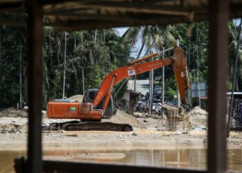 JENGKAUT melakukan kerja-kerja mendalamkan Lata Celak selepas kawasan itu dilanda banjir kali kedua di Sungai Kupang, Kampung Iboi, Kedah. - UTUSAN/ SHAHIR NOORDIN