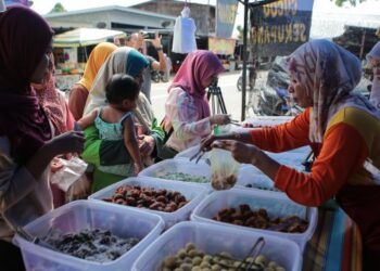 ORANG ramai membeli aneka kuih-muih yang dijual pada harga 10 sen atau sekupang setiap sebiji sebagai juadah untuk berbuka puasa di Felda Lubuk Merbau, Padang Terap. - FOTO/SHAHIR NOORDIN
